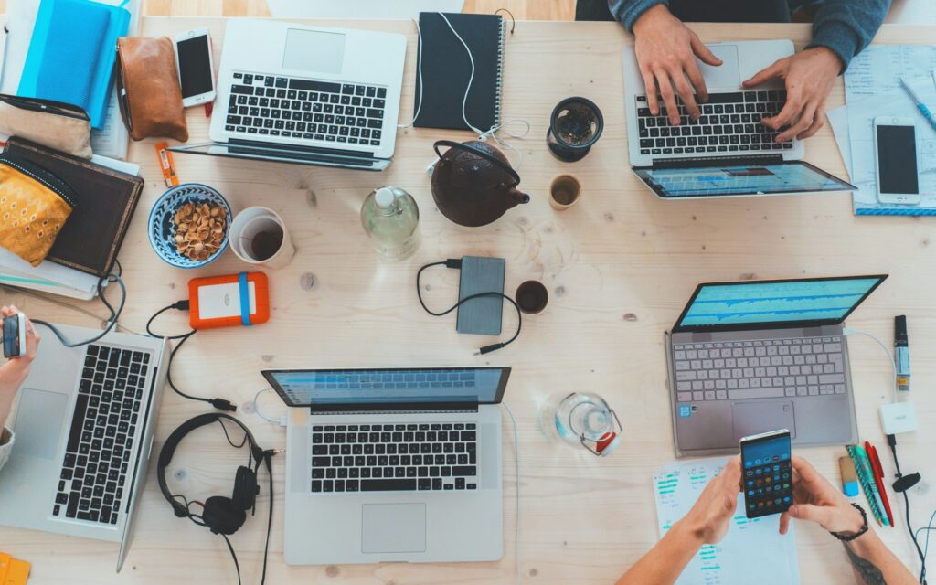 Team arbeitet gemeinsam am Schreibtisch von oben gesehen, kleine Betriebe wollen Fachkräfte gewinnen