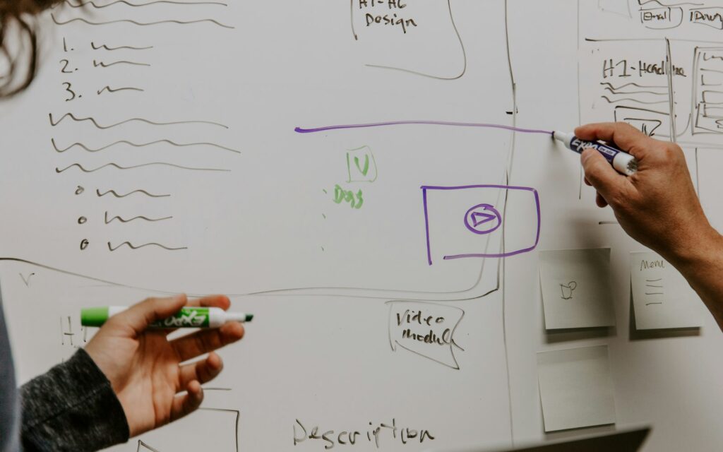 Zwei Personen skizzieren am Whiteboard die ersten 30 Tage nach der Unternehmensgründung