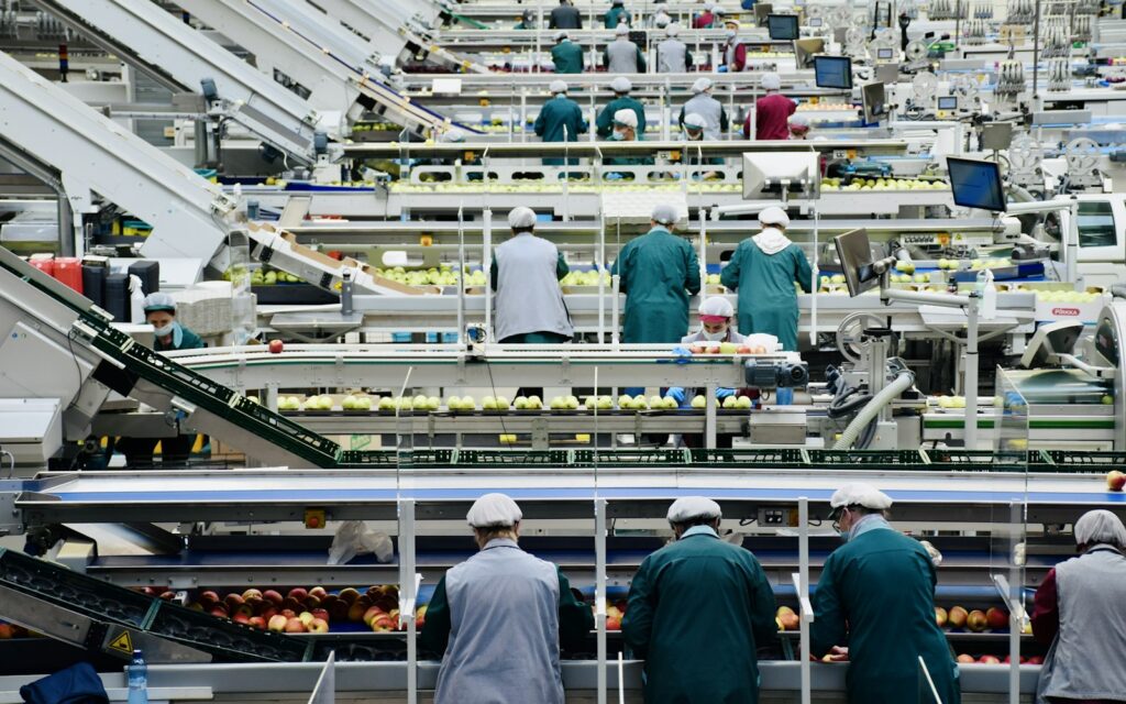 Mitarbeiter in einer Werkhalle, deren Schichten per Arbeitszeiterfassung dokumentiert werden