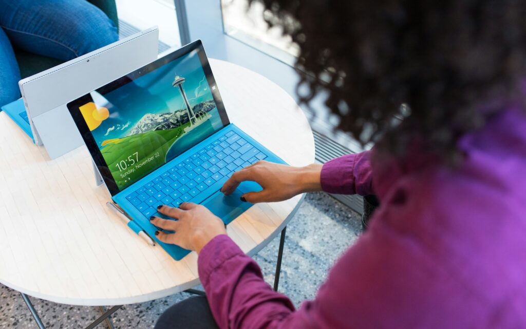 Barrierefreie Website: Person bedient ein Tablet-Notebook am runden Tisch