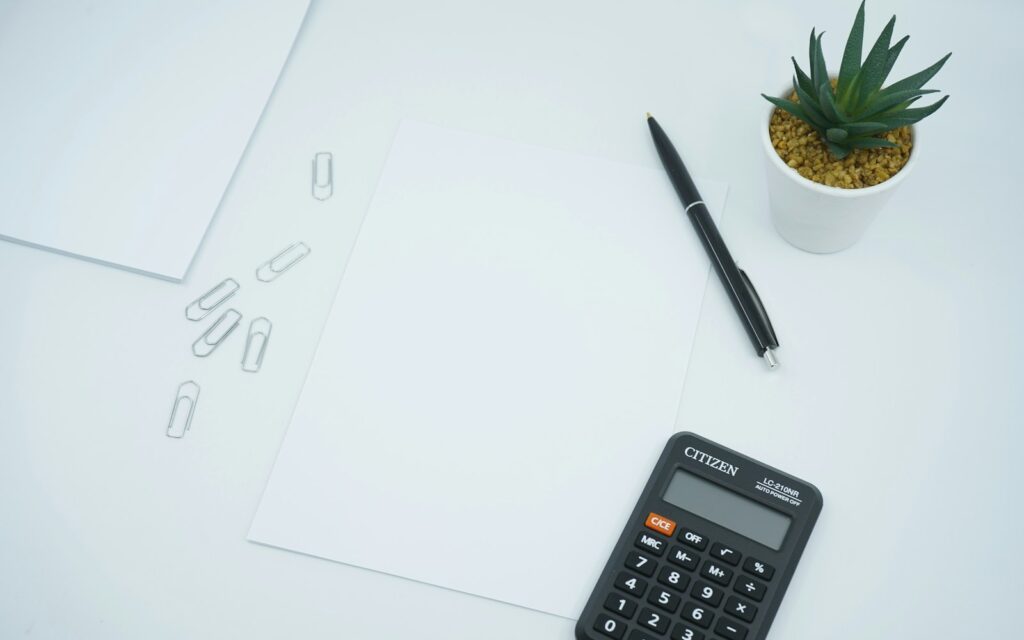 Taschenrechner und Stift auf Papier: Degressive AfA für eine Investition berechnen