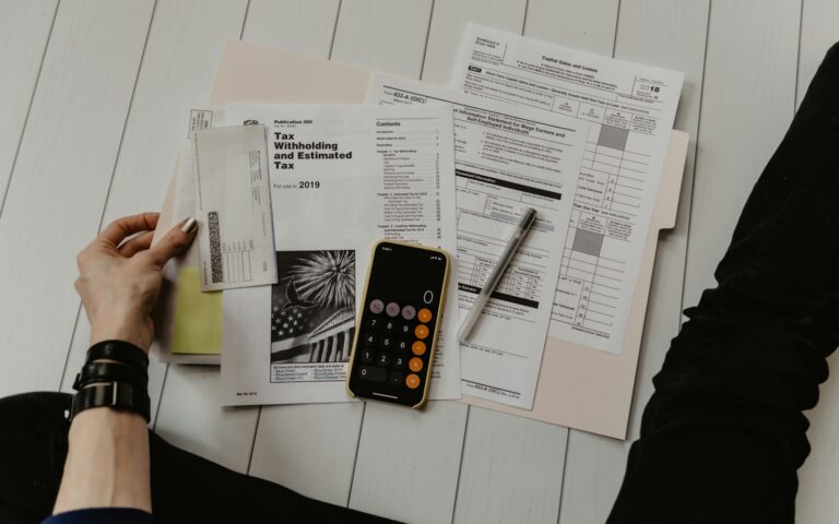 Taschenrechner und Unterlagen auf dem Schreibtisch – Umstellung auf die E-Rechnung im Unternehmen