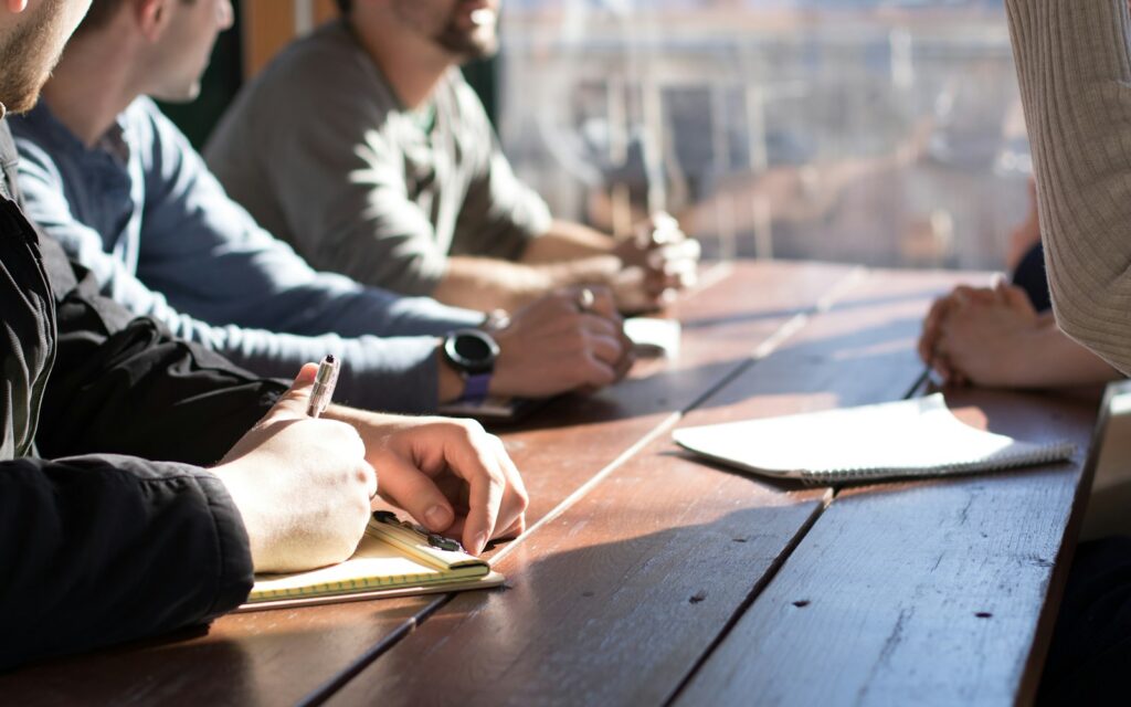Neue Führungskraft bespricht mit ihrem Team am Tisch die ersten Ziele