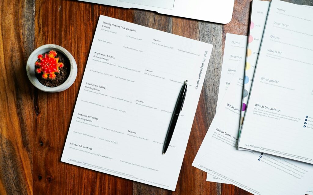 Holztisch mit Formularen und Stift zum Gewerbe anmelden