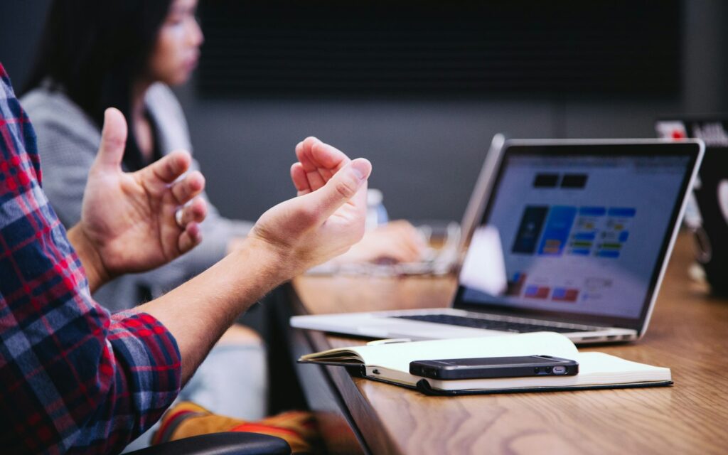 Besprechung mit Laptop und Smartphone zur Pflege des Google-Unternehmensprofils