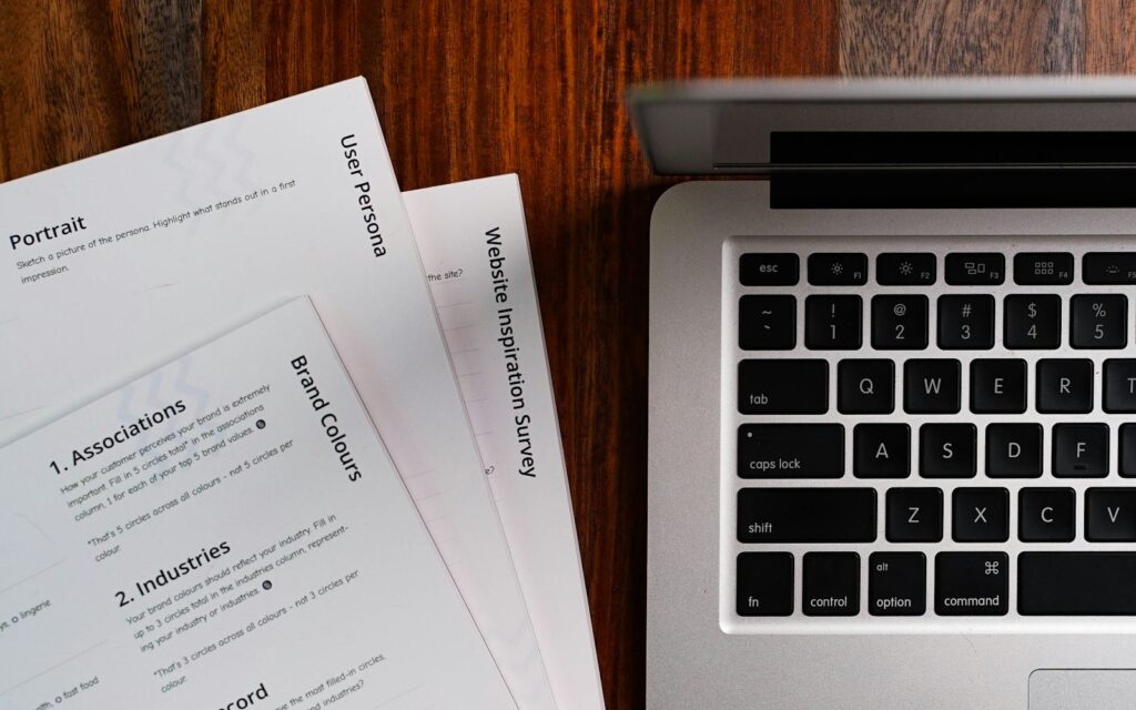 Laptop auf einem Holztisch, an dem das Impressum der Firmenwebsite geprüft wird
