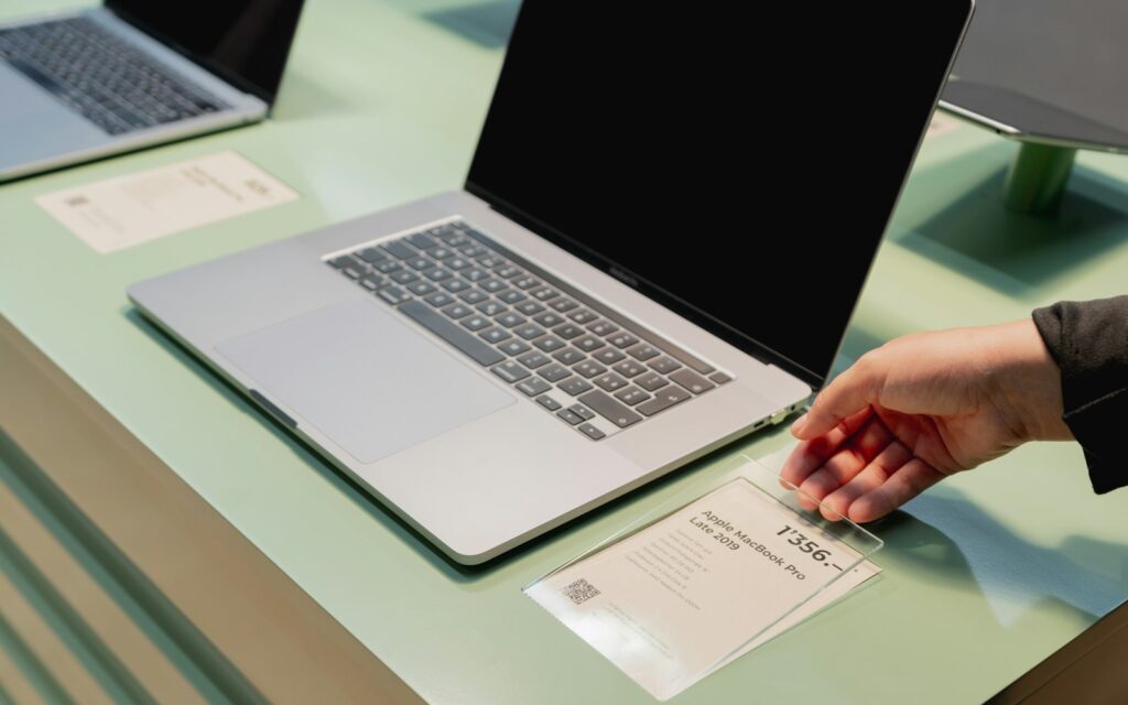 Hand auf einem Laptop beim Bearbeiten der Impressum-Seite einer Website