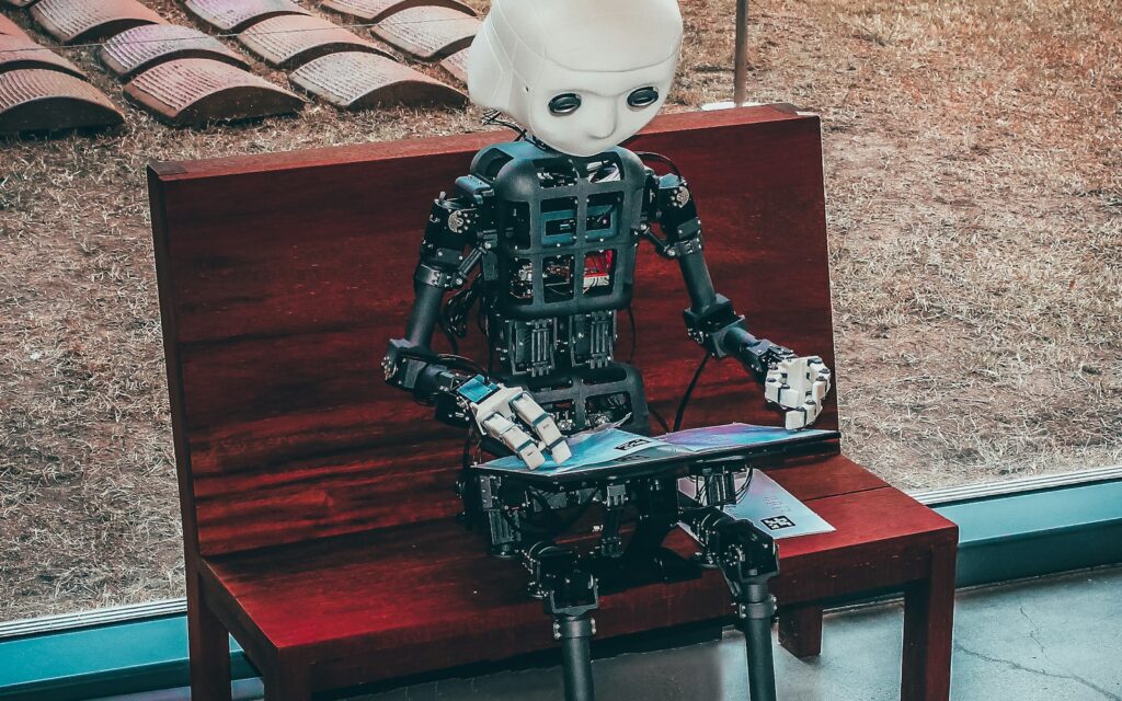 Roboterfigur liest auf einer Bank – KI-Assistenten lernen aus Texten und Dokumenten