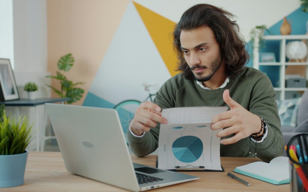 Selbstständiger prüft am Laptop seine Umsätze für die Kleinunternehmerregelung