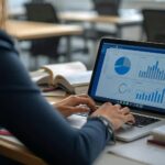 Frau prüft am Laptop Diagramme zu KPIs für kleine Unternehmen