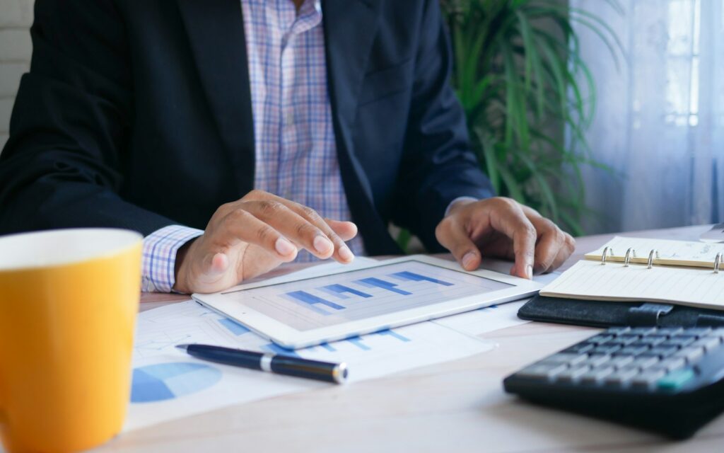 Unternehmer im Anzug mit Tablet für sein Dashboard mit KPIs für kleine Unternehmen