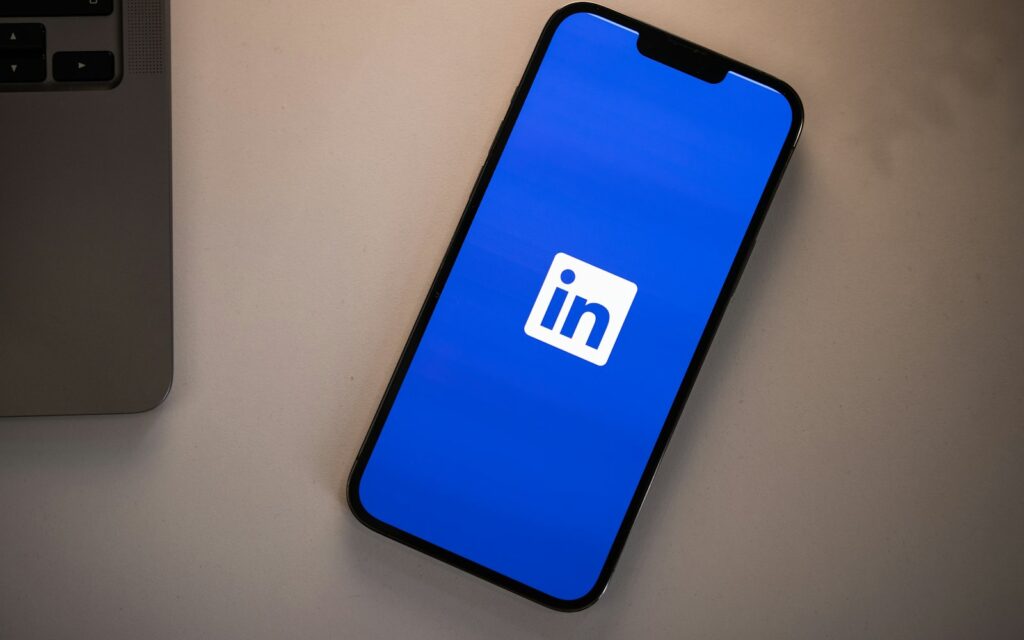 Smartphone mit LinkedIn-Logo auf dem Schreibtisch, Symbolbild für den LinkedIn-Newsletter