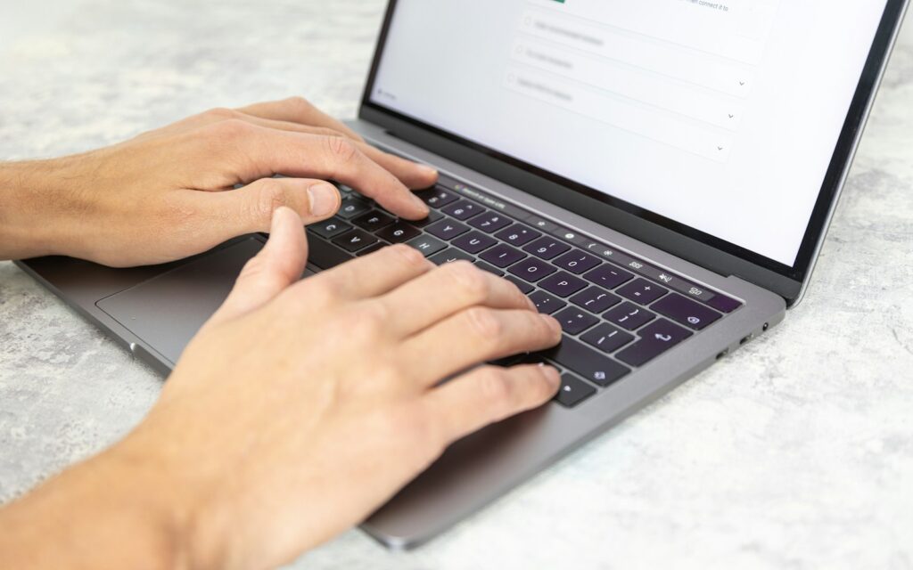 Person tippt auf einem Laptop die nächste Ausgabe für den LinkedIn-Newsletter