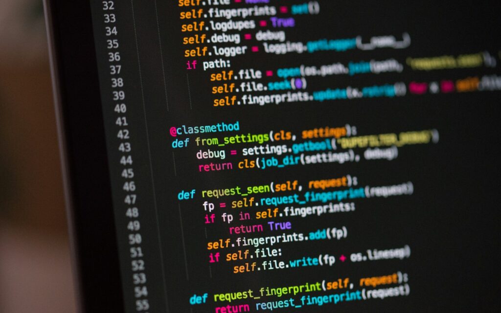 Monitor mit Quelltext: Eine llms.txt fasst Inhalte einer Website für KI-Agenten zusammen