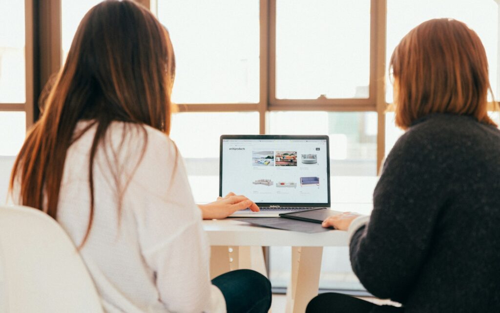 Zwei Frauen prüfen am Laptop eine Microsoft-365-Alternative für ihr Unternehmen