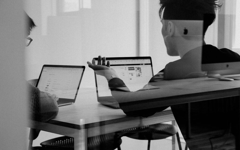 Person arbeitet abends am Laptop an Inhalten für ihr Newsletter-Marketing (Schwarz-Weiß-Foto)