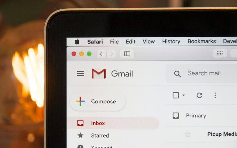 Aufgeklappter schwarzer Laptop auf dunklem Tisch als Symbolbild für Phishing-Mails erkennen im Büro