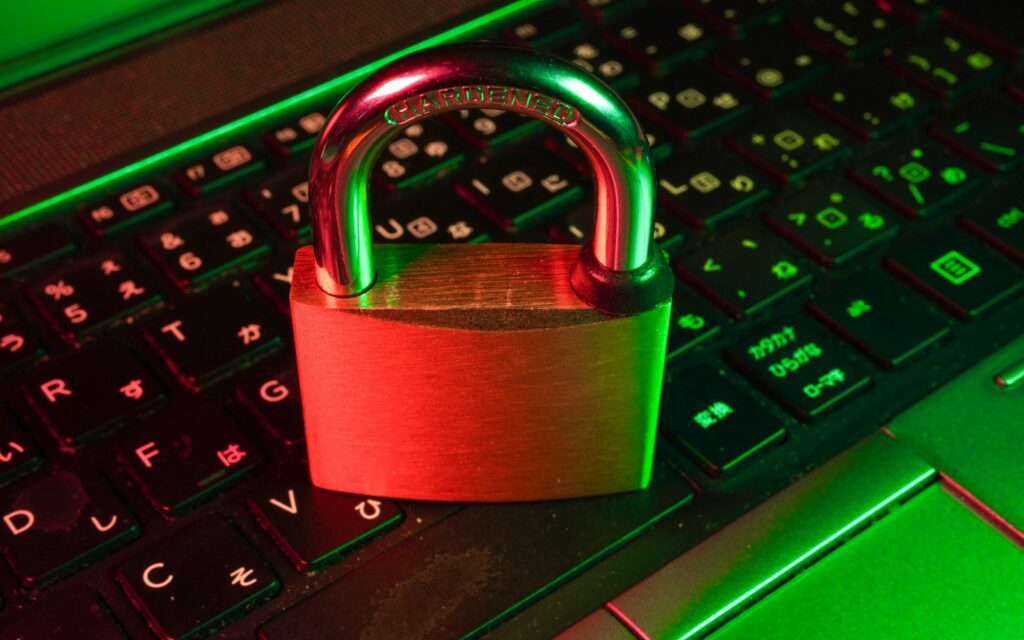 Rotes Vorhängeschloss auf schwarzer Computertastatur als Symbol für Schutz vor Ransomware