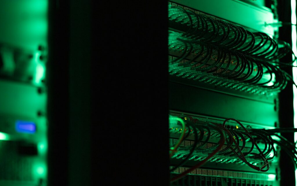 Server-Rack mit Netzwerktechnik in dunklem Raum, Backup-Infrastruktur gegen Ransomware