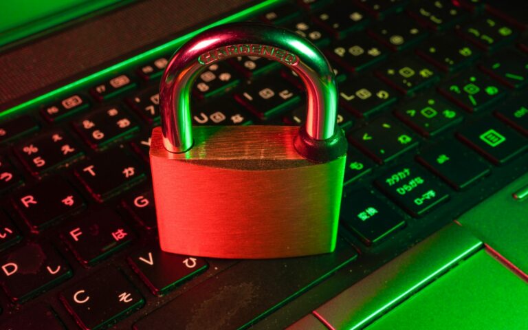 Rotes Vorhängeschloss auf schwarzer Computertastatur als Symbol für Schutz vor Ransomware