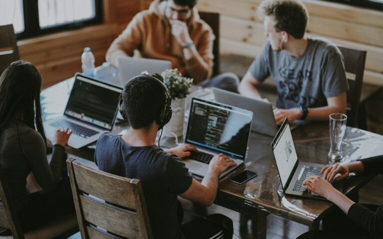 Team arbeitet an Laptops an einem gemeinsamen Projekt im Rahmen einer Kooperation mit Start-ups
