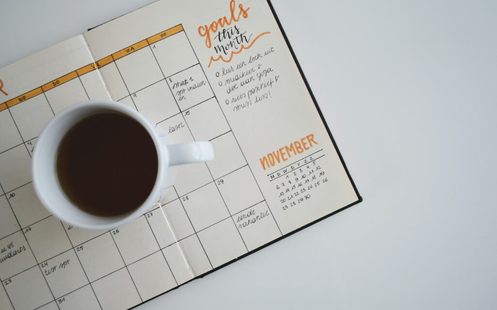 Kaffeetasse auf einem Wochenplaner als Symbol für mehr Freizeit durch die Vier-Tage-Woche