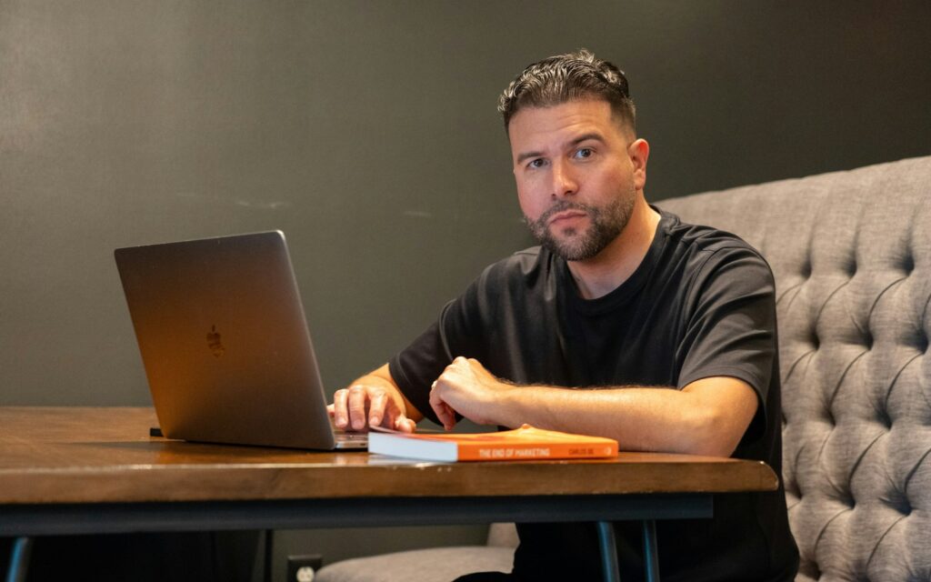 Mann arbeitet am Laptop an seiner Website und entscheidet sich zwischen WordPress oder Baukasten
