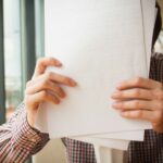 Geschäftsführerin prüft Unterlagen zur Zahlungsunfähigkeit ihrer GmbH
